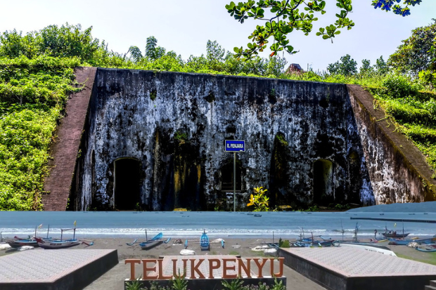 pesona pantai teluk penyu dan cerita sejarah benteng pendem
